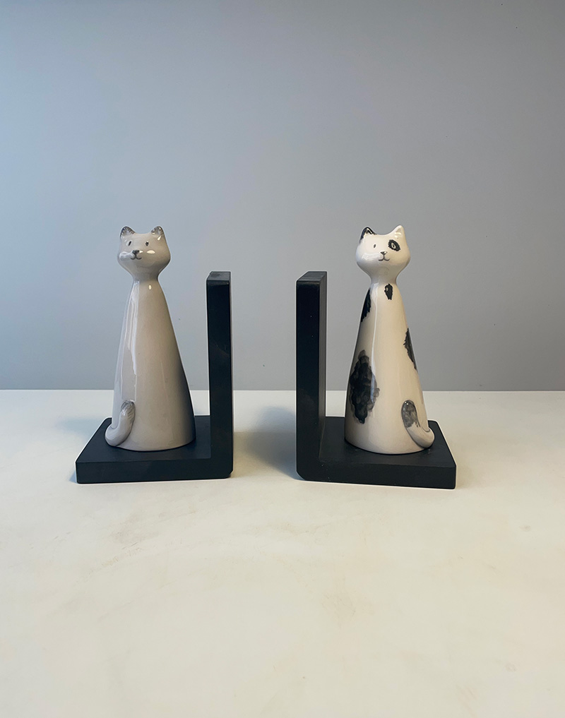 Coppia di reggilibro. Sul supporto in legno due gattini in ceramica. Altezza cm 23. Fatto a mano. Copia unica.