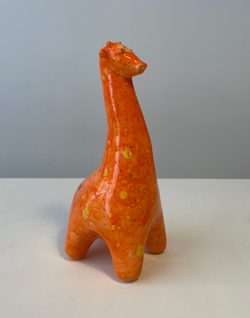 Giraffa in ceramica. Altezza cm  26. Colore base arancio, maculato nei toni del giallo. Pezzo unico. Fatto a mano.