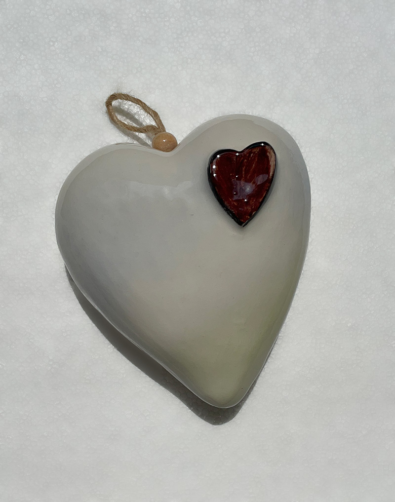 Pendente in ceramica. A forma di cuore con un piccolo cuore in rilievo. Misure cm 11x11x6. Fatto a mano.