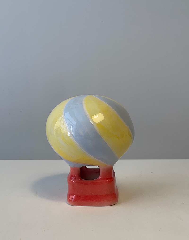 Piccola mongolfiera in ceramica. Altezza cm 14. Colore sfumato nei toni del giallo e dell'azzurro. Fatto a mano. Copia unica.