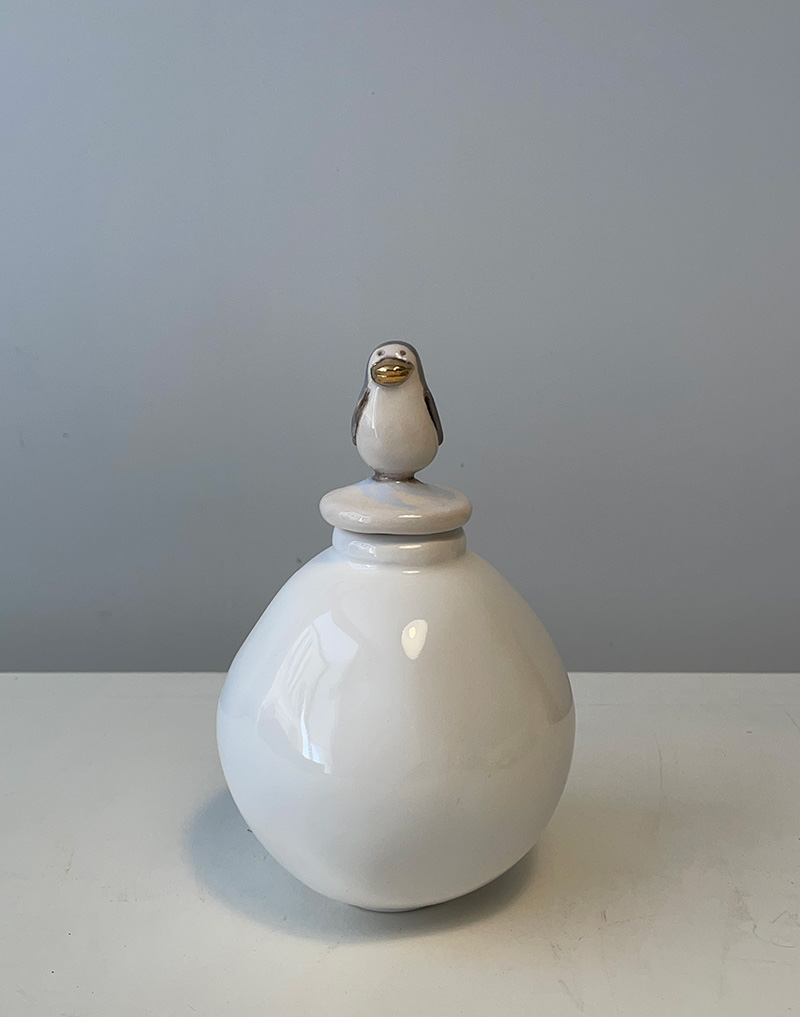 Ampolla in ceramica a forma di sfera. Colore chiaro. Sul tappo dell'ampolla un piccolo pinguino. Altezza cm 18. Fatto a mano. Pezzo unico.