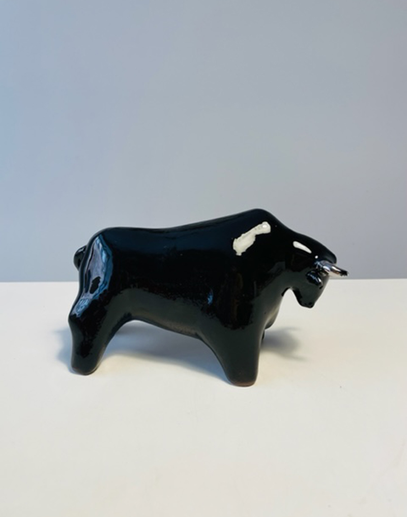 Polished black glazed ceramic bull with third-fire platinum luster decorations. Length 20 cm. Height 12 cm.